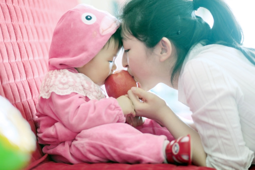 Baby and mather eating apple together