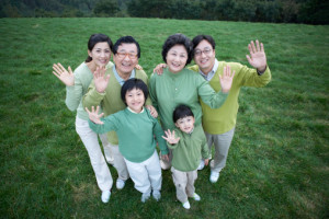 A Korean big family greeting on the grass with a smile