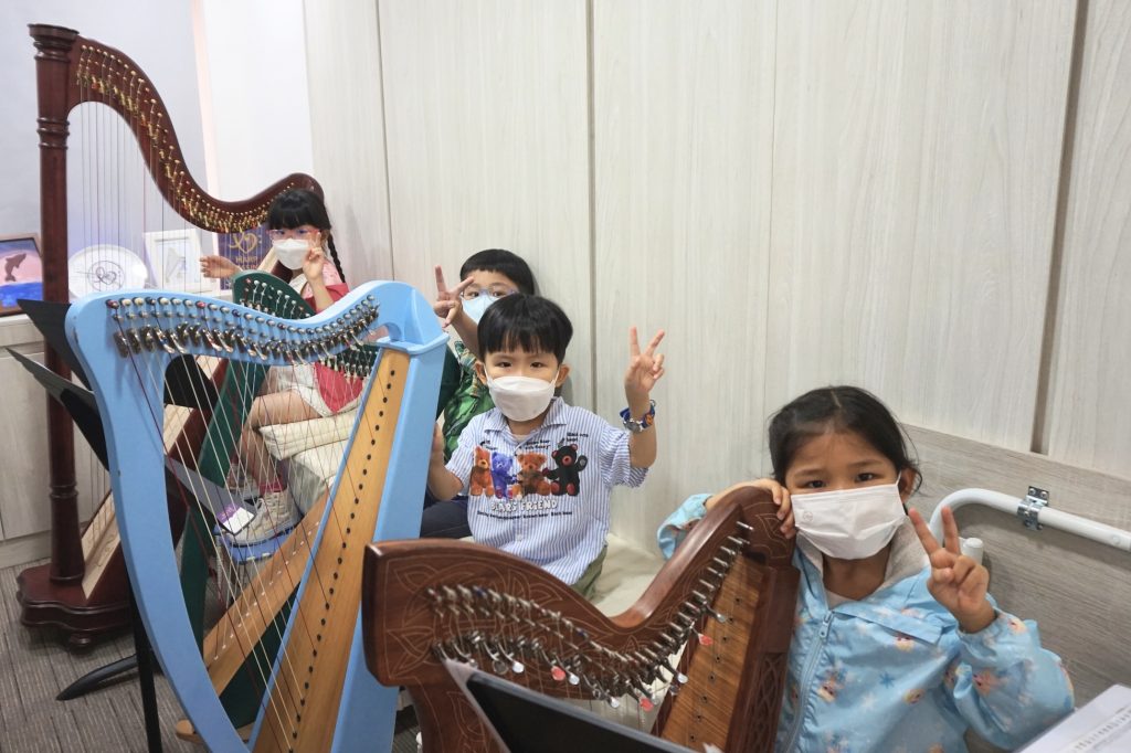 病童在「豎琴同樂日」一嘗彈奏豎琴的滋味，彼此玩得不亦樂乎。